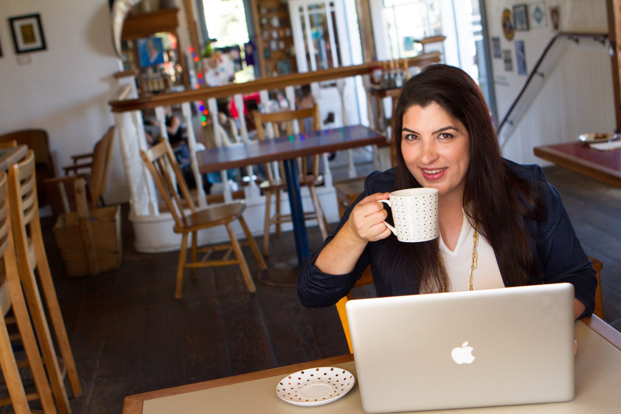 Julia A. Bennett drinking coffee in from of a laptop